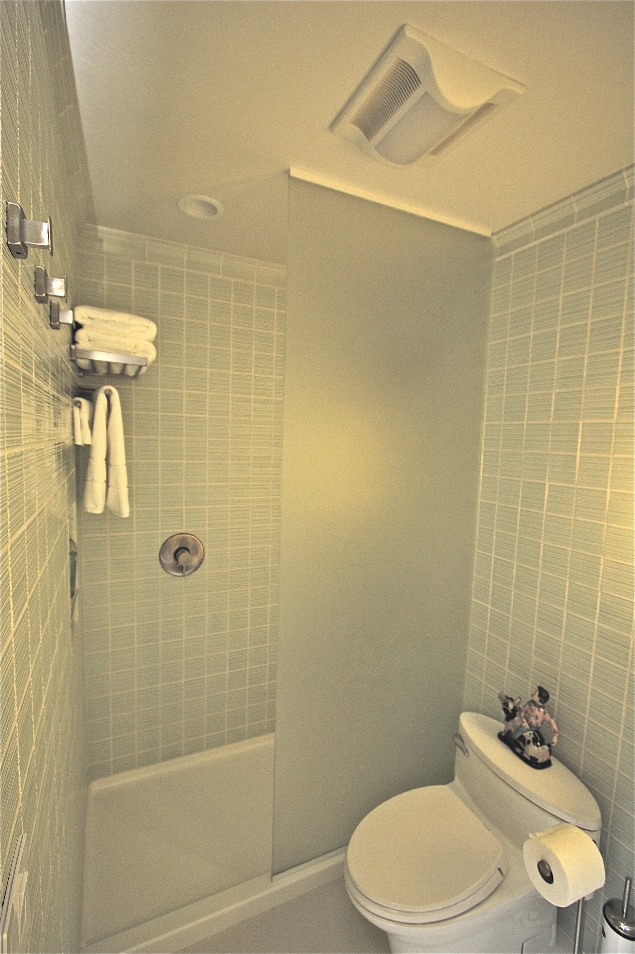Shower has glass partition but no door.