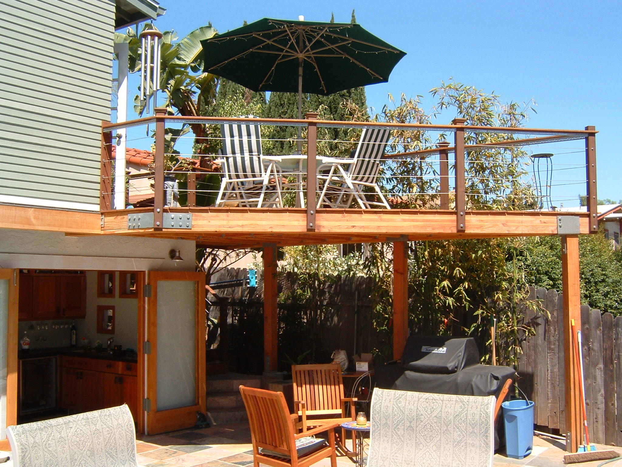  A beautiful angular deck with cable railings and an exterior stairway provide visual and physical access to the kitchen. 