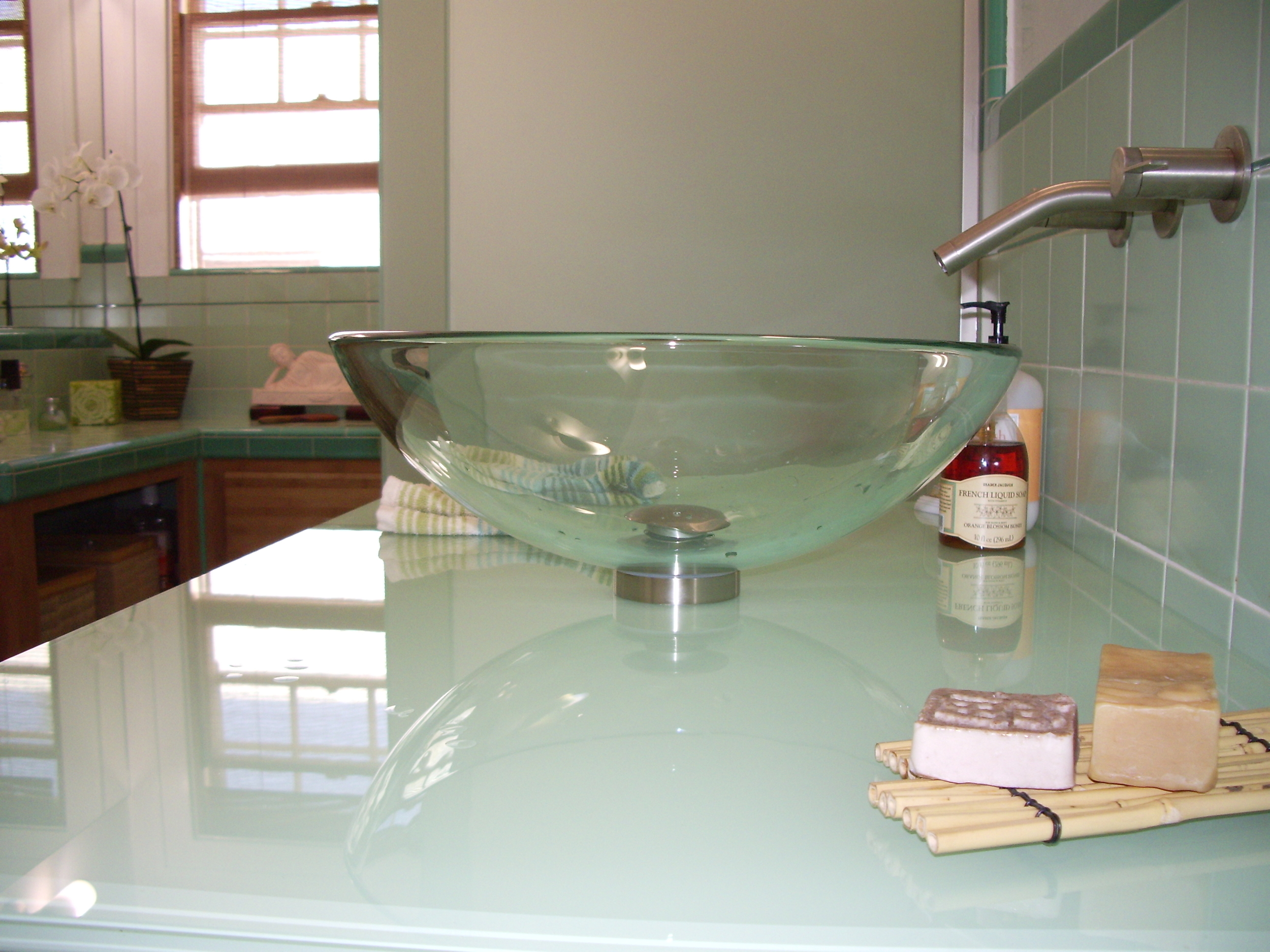  After:&nbsp;Glass vessel sink, glass countertop which was back-painted to match tiles and mattelux glass frameless tub / shower enclosure. 