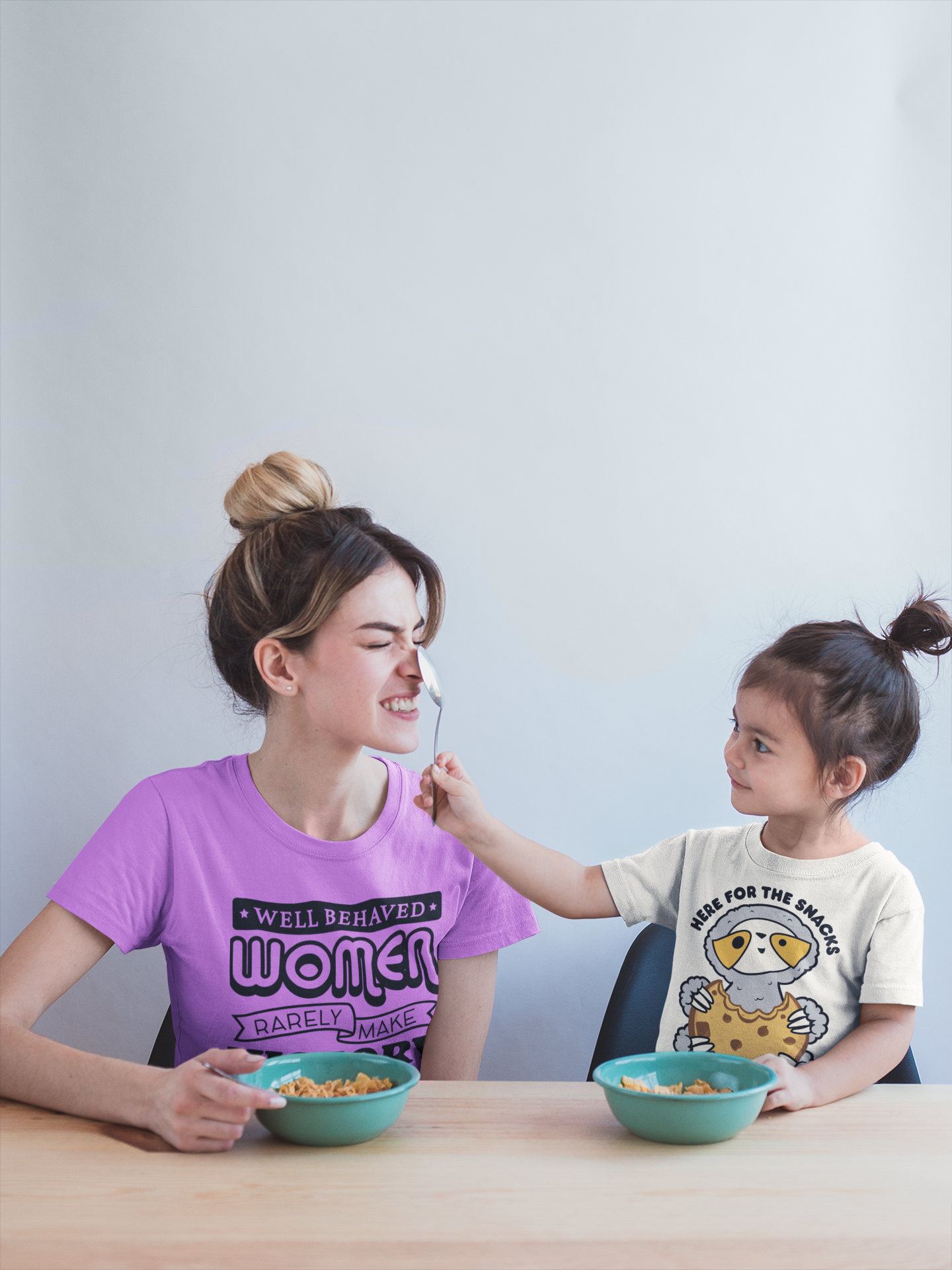 mom-and-daughter-wearing-t-shirts-mockup-during-a-fun-breakfast-a20283.png