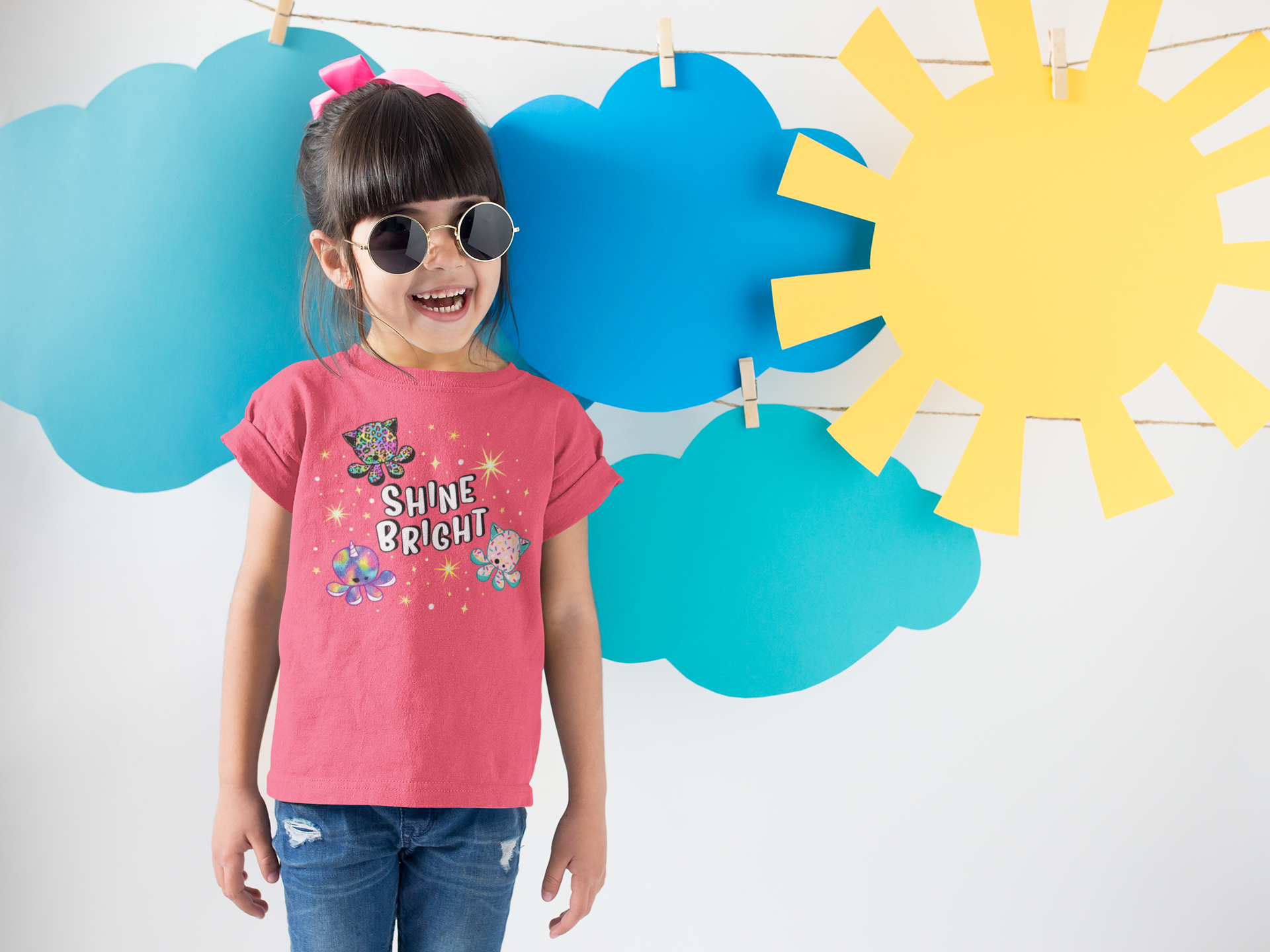 smiling-girl-wearing-a-round-neck-tshirt-template-near-cardboard-sun-and-clouds-a19480.png