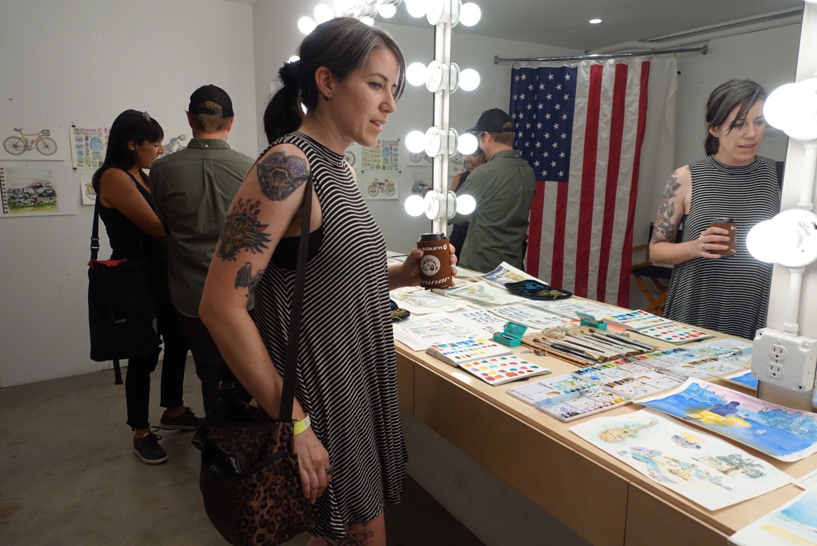 Megan Rose perusing Chris McNally's art on display at the premiere of "Roll With It" photo by Jen Abercrombie