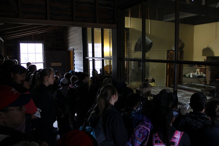 A room tightly packed with school kids watching the confectionist at work. This would have been a fire hazard back in the United States.