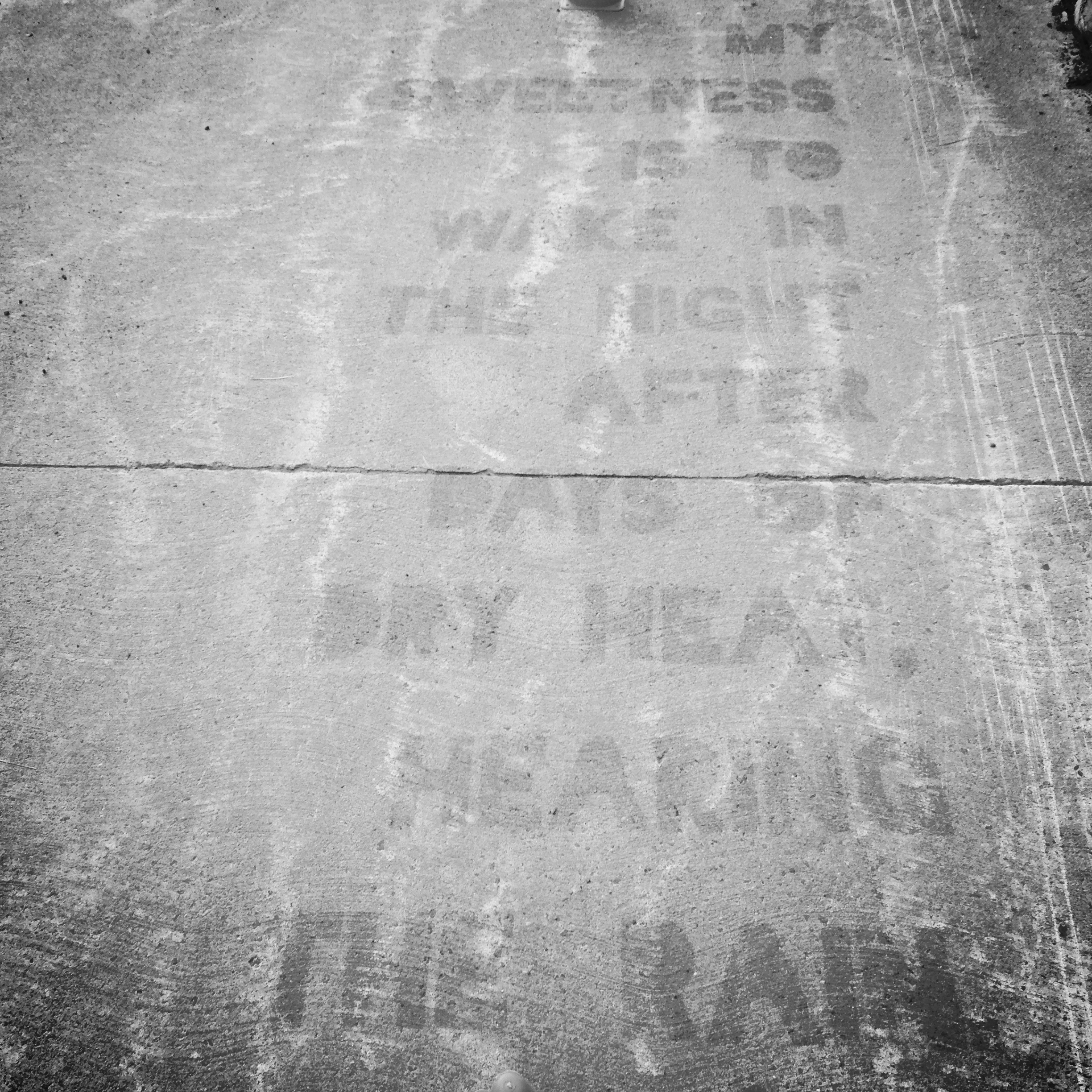 The spray is setting after stencilling. On a rainy day, it will appear the reverse (dry letters, wet ground).