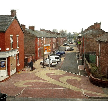 A shared space in Manchester, England. Many Americans also live on streets with no segregation (no sidewalks and bike lanes) - yet consider it inferior to this example. I guess urbanists want us to pave our streets in something other than asphalt before they will consider it a shared space.