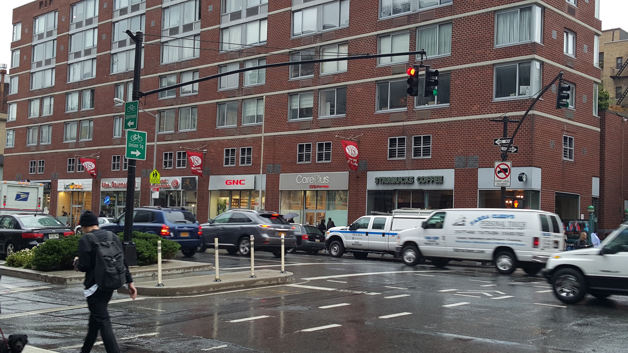 A large building in Manhattan divided into multiple destinations at ground level.