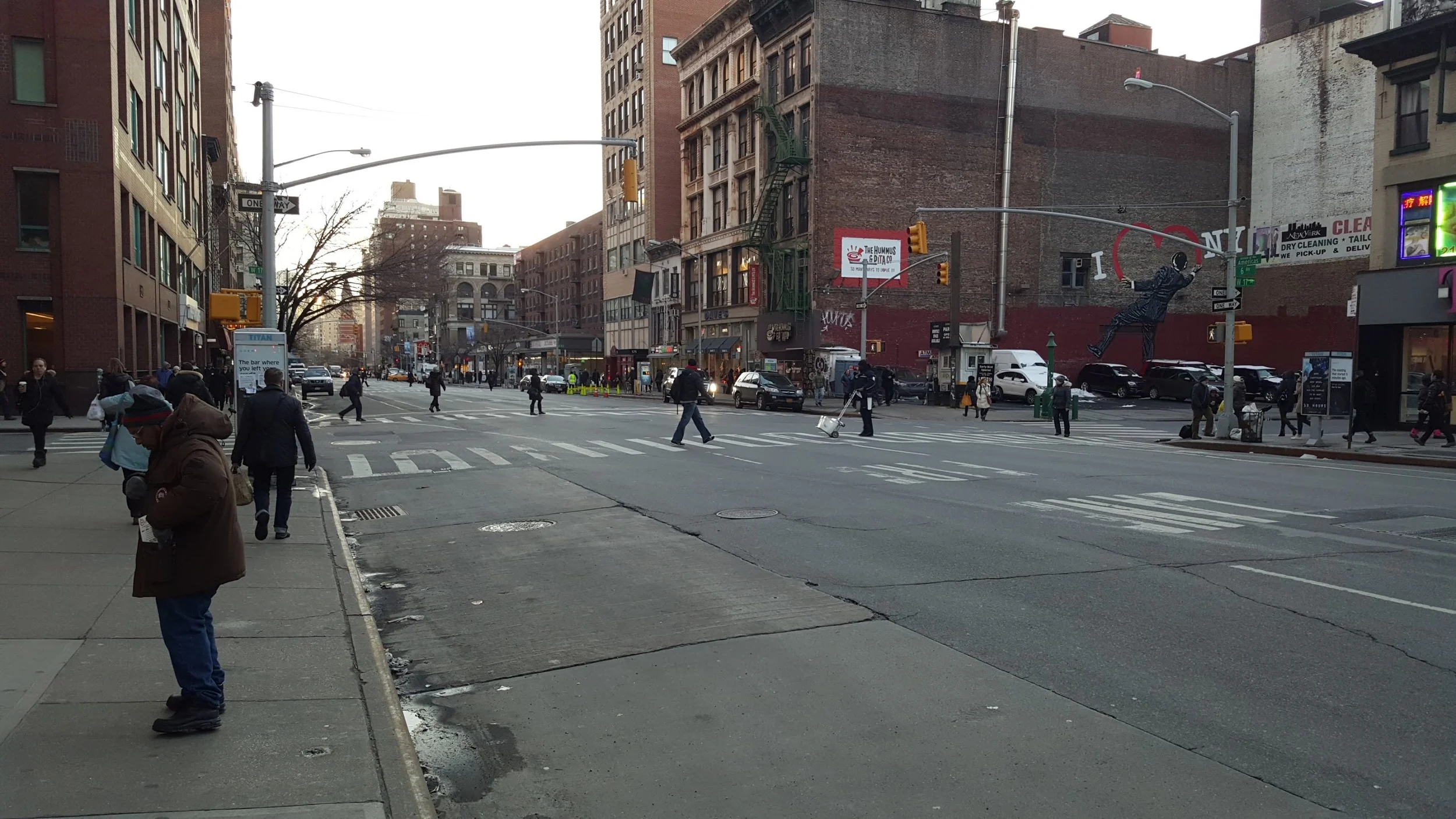 Everyone looking down the street in Manhattan as they cross. Perhaps they are not fully trusting the signal saying that nothing is going to hit them?