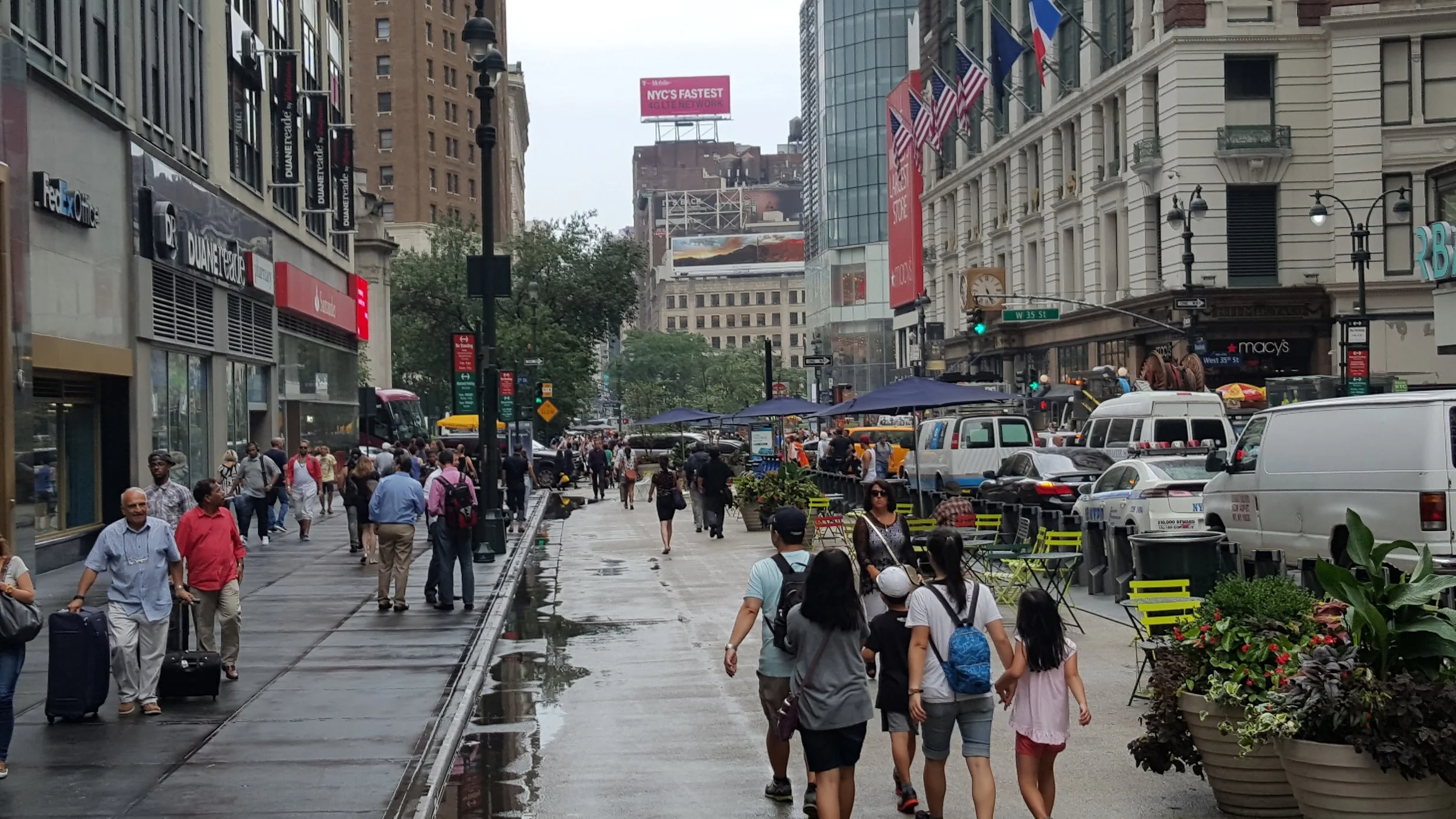 A sidewalk extended out in Manhattan using tables, chairs, and planters.