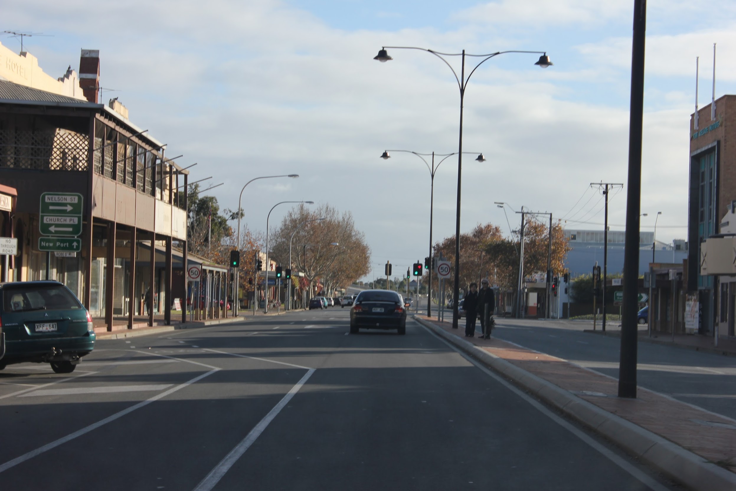 A street in Adelaide with people waiting on a pitiful island in the middle.