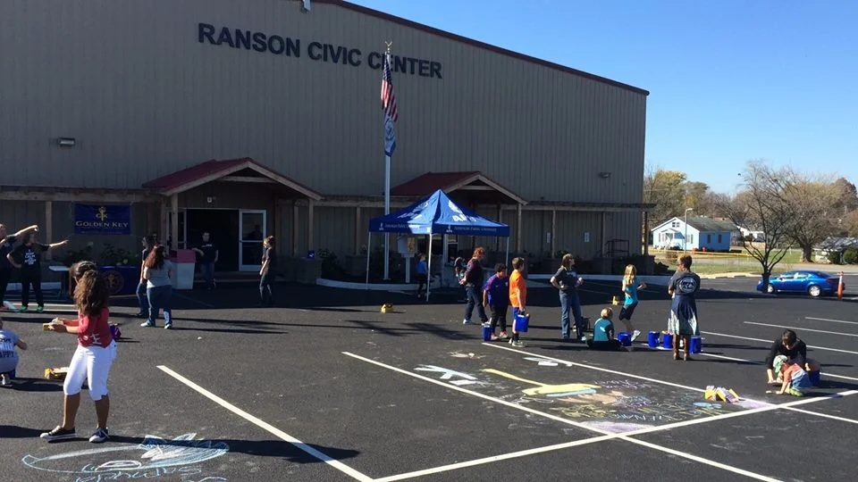 Children in Ranson making good use of an empty parking lot with chalk