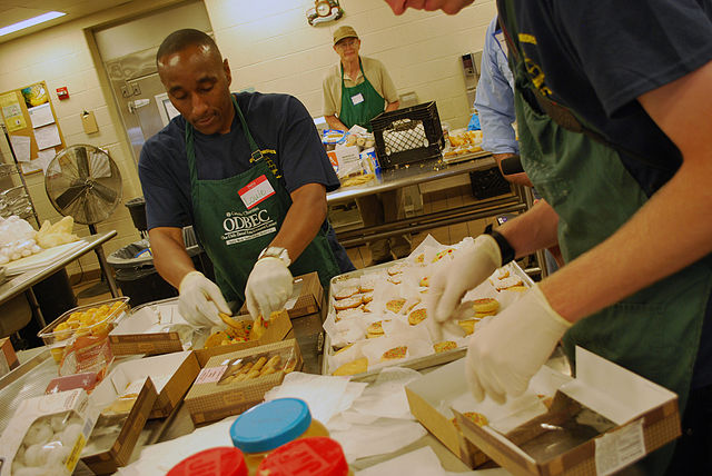 Volunteers prepare a meal for the hungry in a large-scale kitchen, something most houses of worship have ( source )