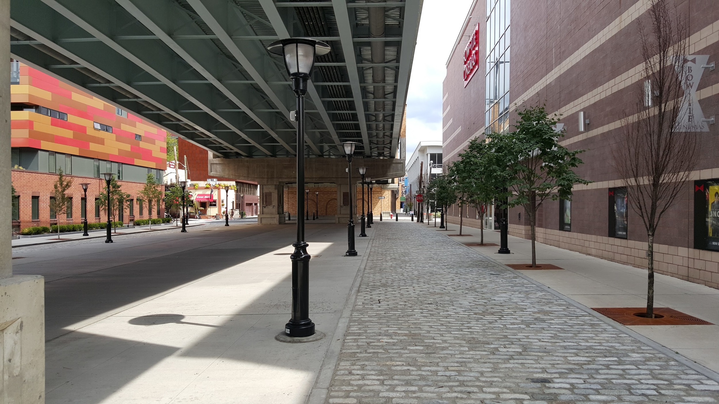 14th Street under the viaduct has two cars lanes separated by either side. Note the Belgian block car lanes and the lack of curbs.