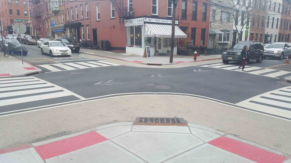 A crosswalk bumpout paved in gravel. It works great, and they did not have to move the curb or drains.