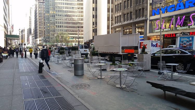 Reclaiming a portion of a street from automobiles in NYC.