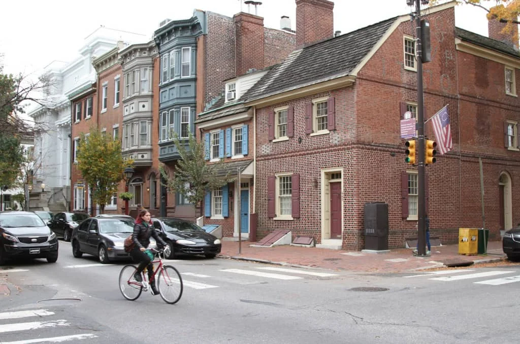 A cyclist can travel safely amongst cars if the street is narrow and speeds are low as a result. (Source: Johnny Sanphillippo)