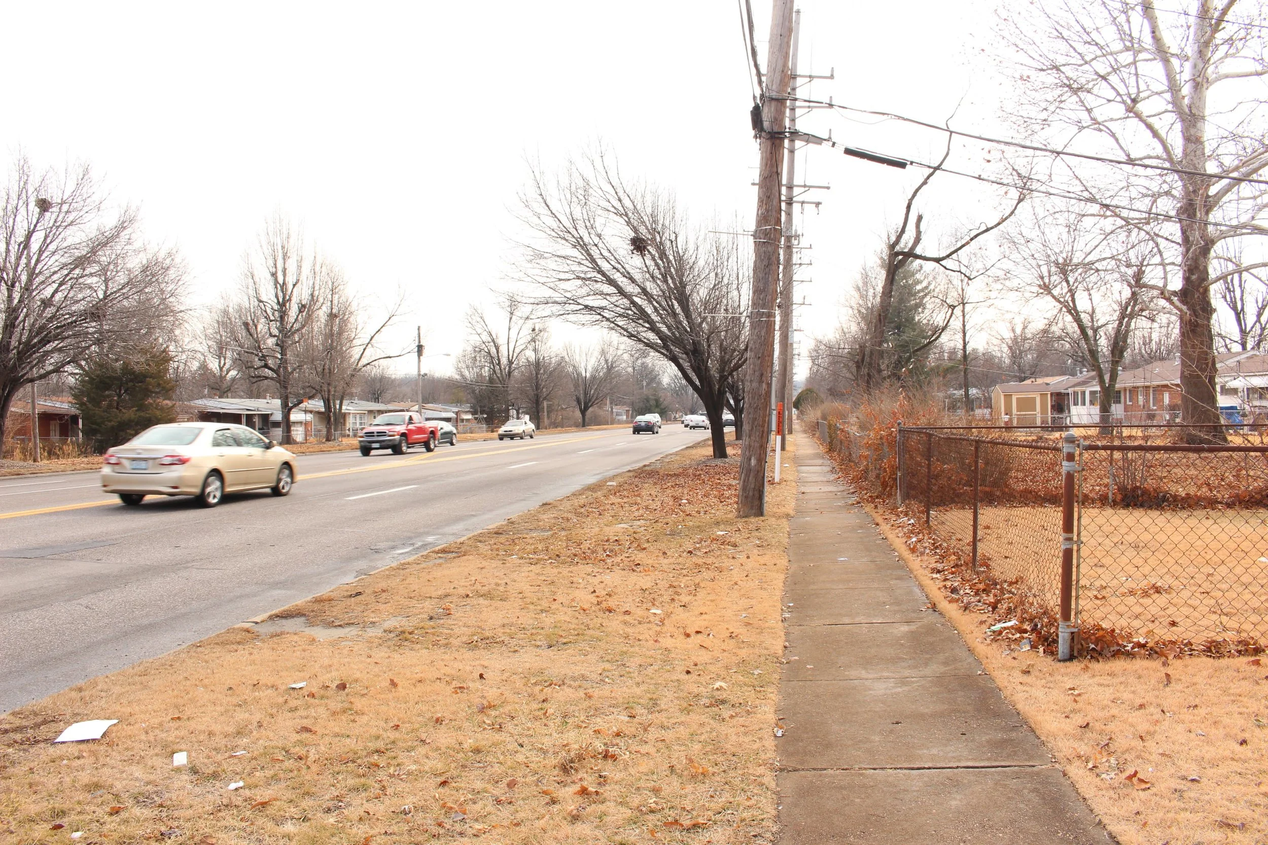 Narrow sidewalks next to speeding cars is a dangerous combination on West Florissant in Ferguson. The lack of safe crossings makes this street even more hostile to anyone outside a car. (Source: Aubrey Byron)