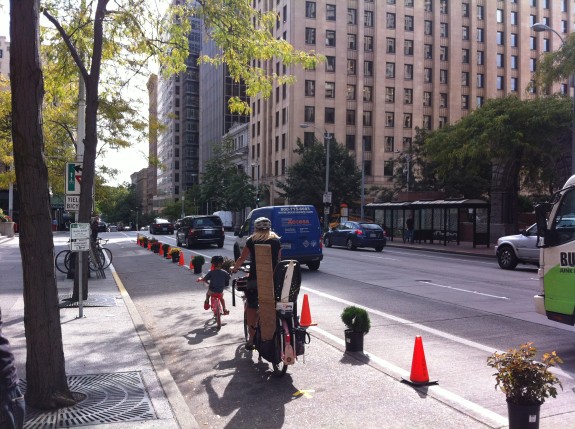 Temporary bike lanes constructed with cones with planters offer an incremental way to test out solutions and refine strategies. (Source: Seattle Bike Blog )