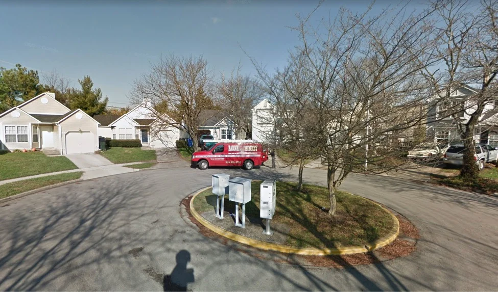 Mailboxes are shared and work vehicles line the streets.