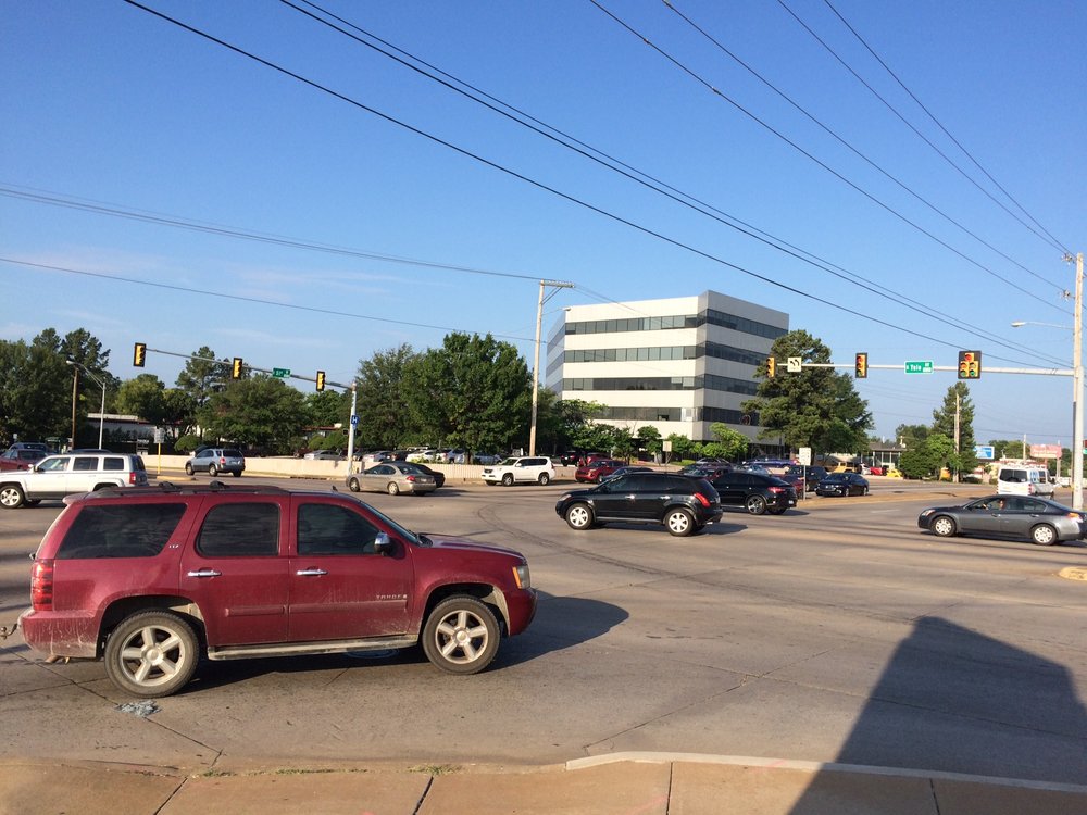 A wide suburban intersection, big enough to accommodate the traffic generated by surrounding auto-oriented development.