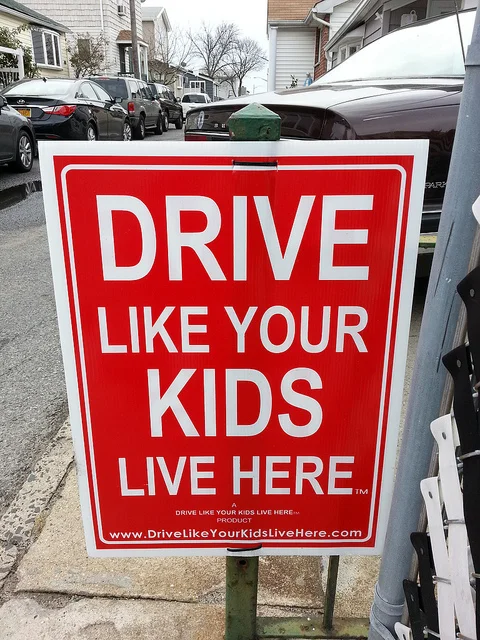 These signs are a common U.S. response to speeders, using an emotional appeal to drivers to slow down. What if we used actual infrastructure to narrow the travel lanes and induce drivers to go more slowly? (Source: Matt Green via Flickr .)