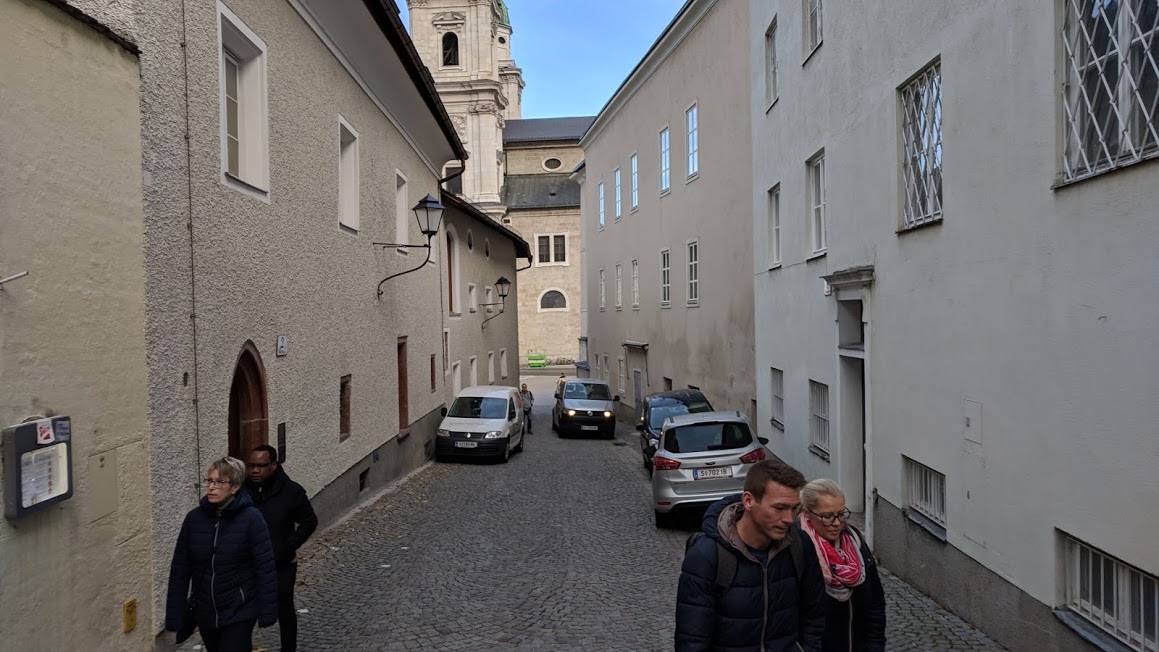 A street with cars that bottlenecks then widens.