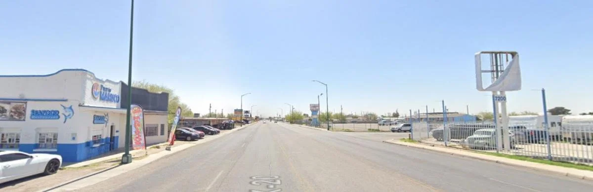 A wide, barren stretch of road with no visible human activity on either side.