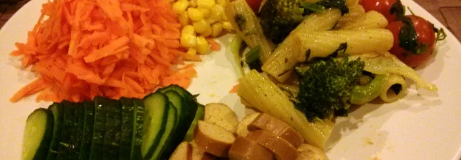 Pasta served with grated carrots, sweetcorn and Wiener