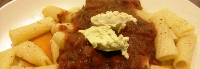 Pasta in a homemade sauce, garnished with soft cheese