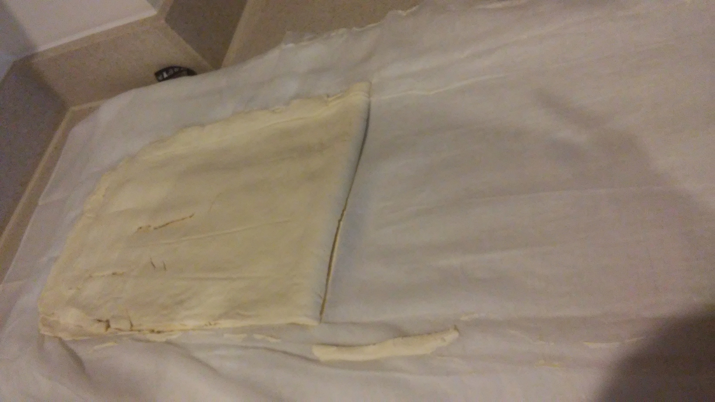 Muslin cloth pulled back, leaving the strained yoghurt on one side