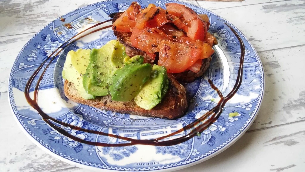 Avocado & grilled vine tomatoes on toast with pepper and olive oil