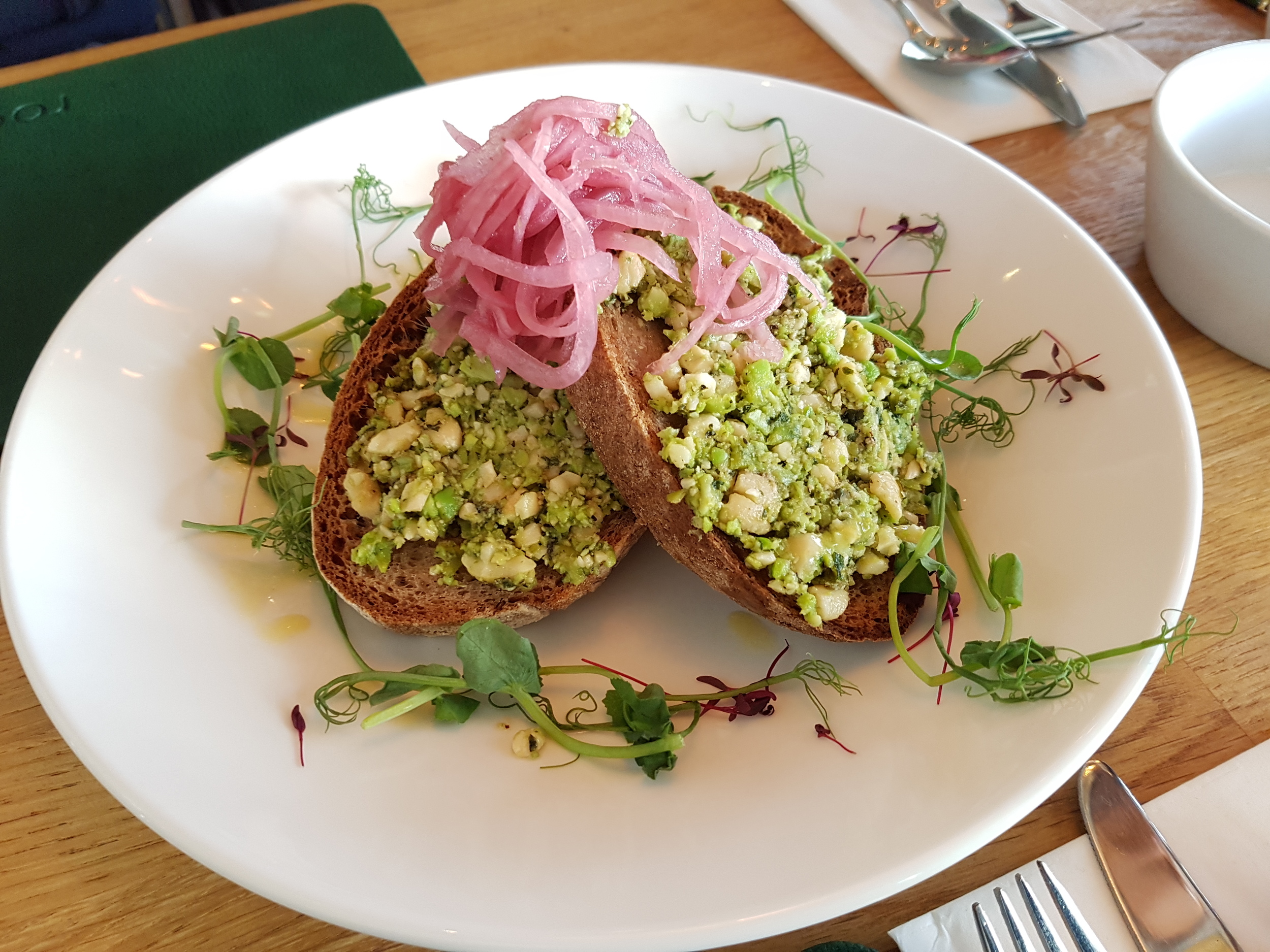 Fresh mint, broad bean & cashew pate on toasted sourdough, garnished with pickled red onion