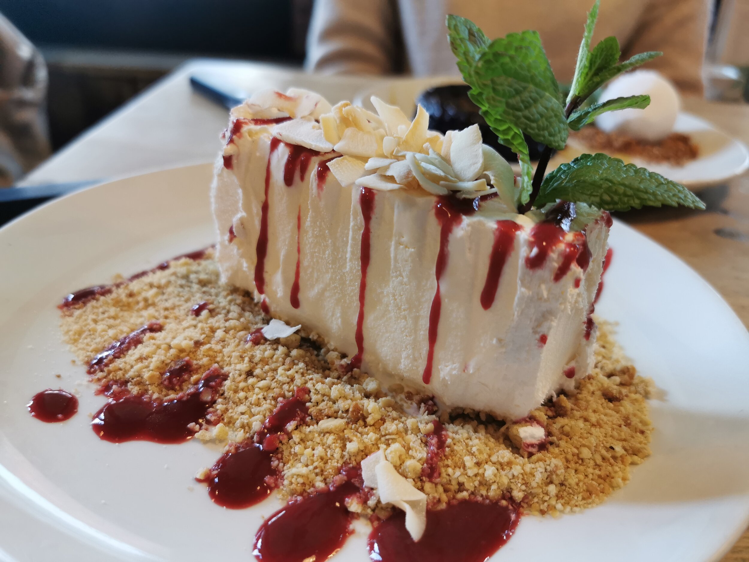 Frozen Amaretto Parfait served with shortbread crumb, coconut flakes &amp; raspberry sauce