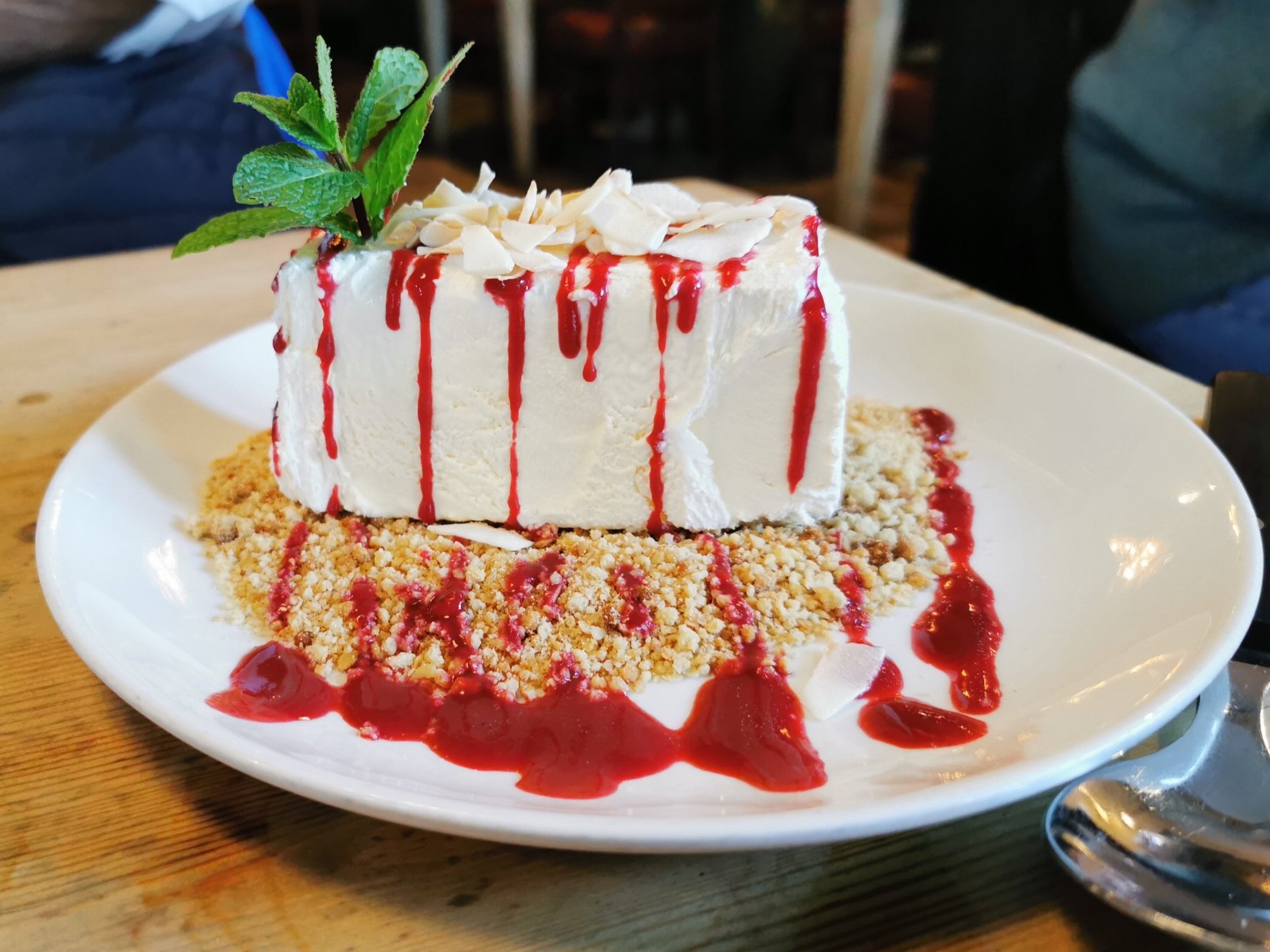 Frozen Amaretto Parfait served with shortbread crumb, coconut flakes &amp; raspberry sauce