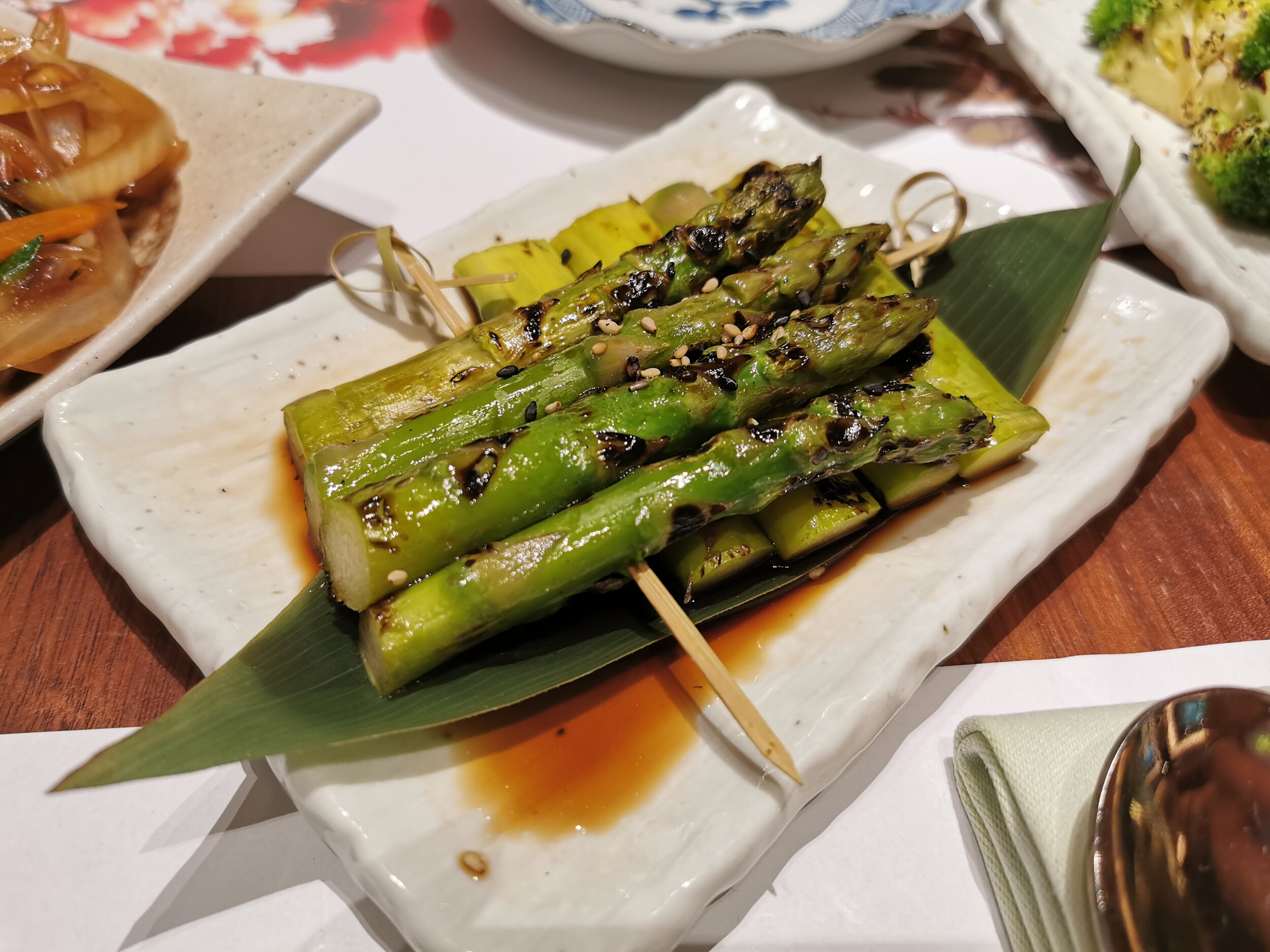 Asparagus skewer served with a yuzu dressing and topped with sesame seeds