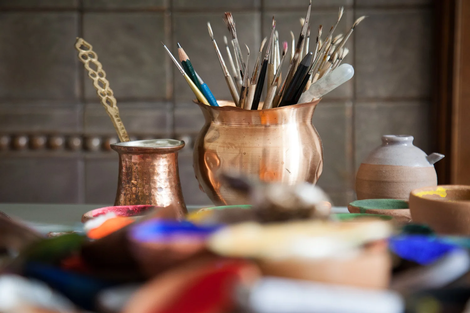 Water containers for mixing and working, an endless supply of brushes, pencils and blades are used to produce such fine detail.
