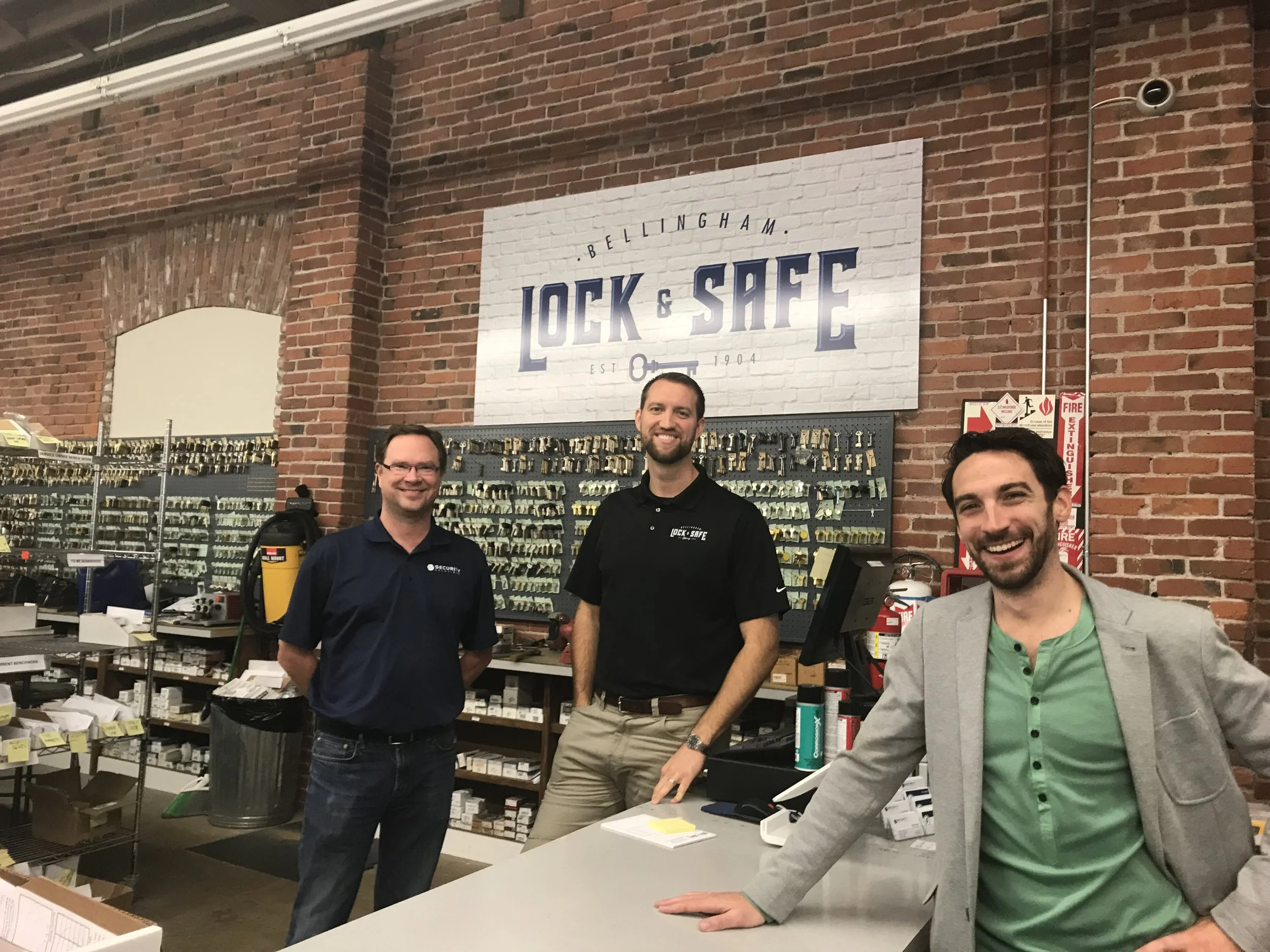 Jamie Vos, left, owner of Security Solutions, Daniel Ford, middle, locksmith manager, and Ray Deck III, right, executive director of Skookum Kids, pose for a picture inside Bellingham Lock & Safe in Bellingham, on Thursday, Oct. 27, 2017.