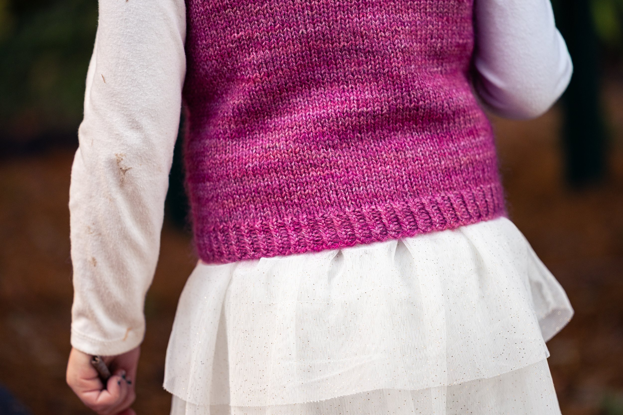 A close up view of the alternating cable cast on and twisted rib hem on the Bittie Bestie Vestie, an easy children's knit sweater vest worked from the bottom up in DK weight and mohair held together.