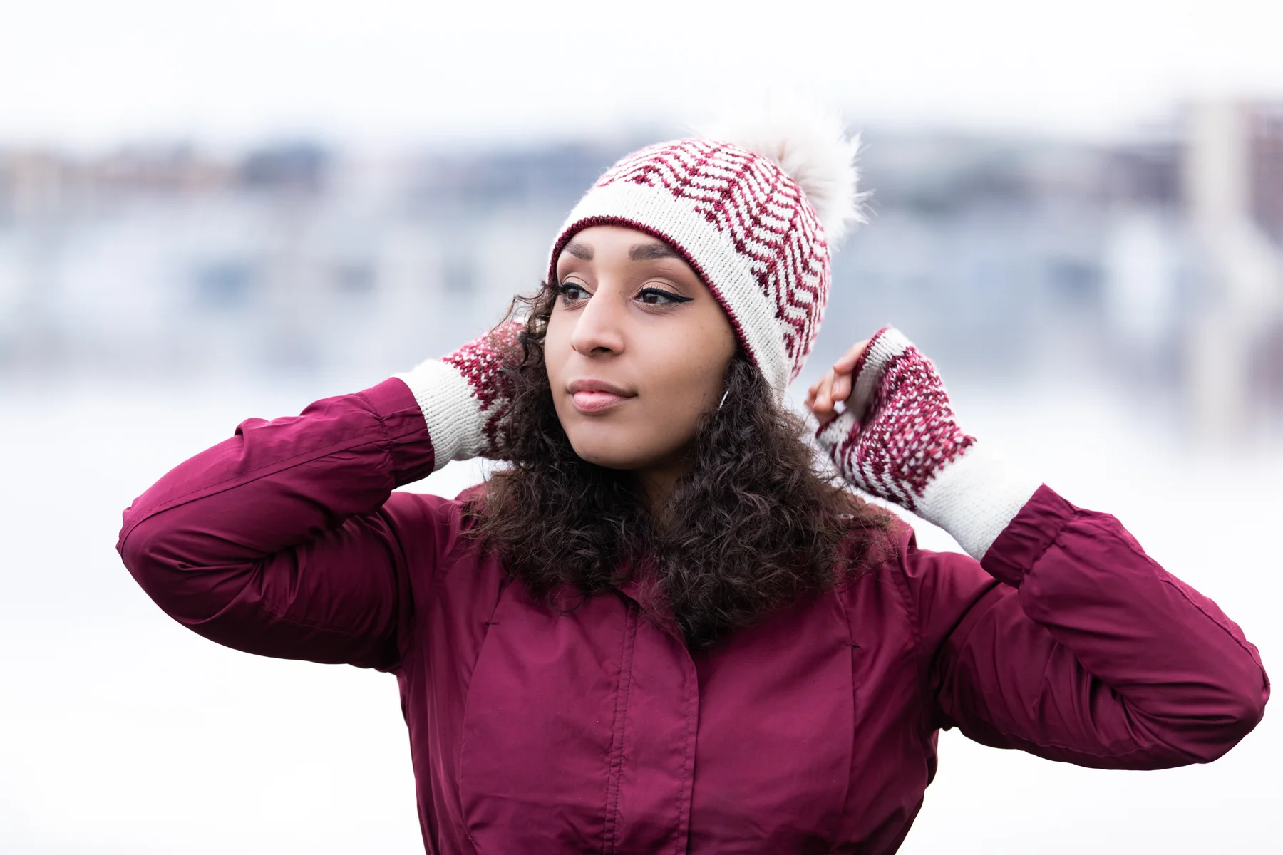 Pacific Northwest designer Vanessa Smith wears the Novemberist hat and mitt set featuring turned hems, beginner-friendly stranded fair isle motifs, and unique shaping in two high-contrast DK yarns.