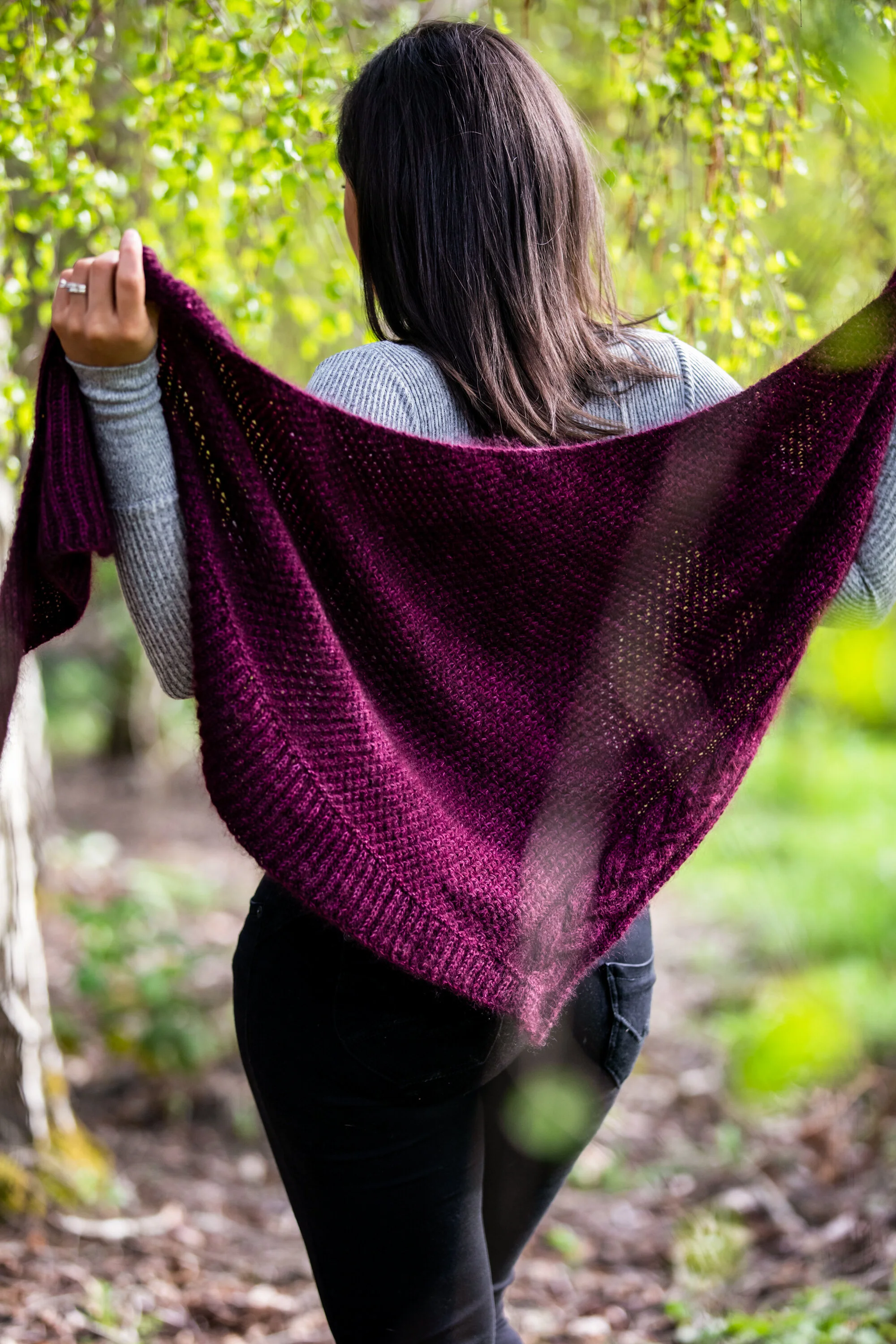 The purple Indira Shawl artfully displayed to highlight its texture and handcrafted beauty. Features fisherman's rib, an alternative to brioche knitting. Knitwear pattern from Vanessa Smith Designs.