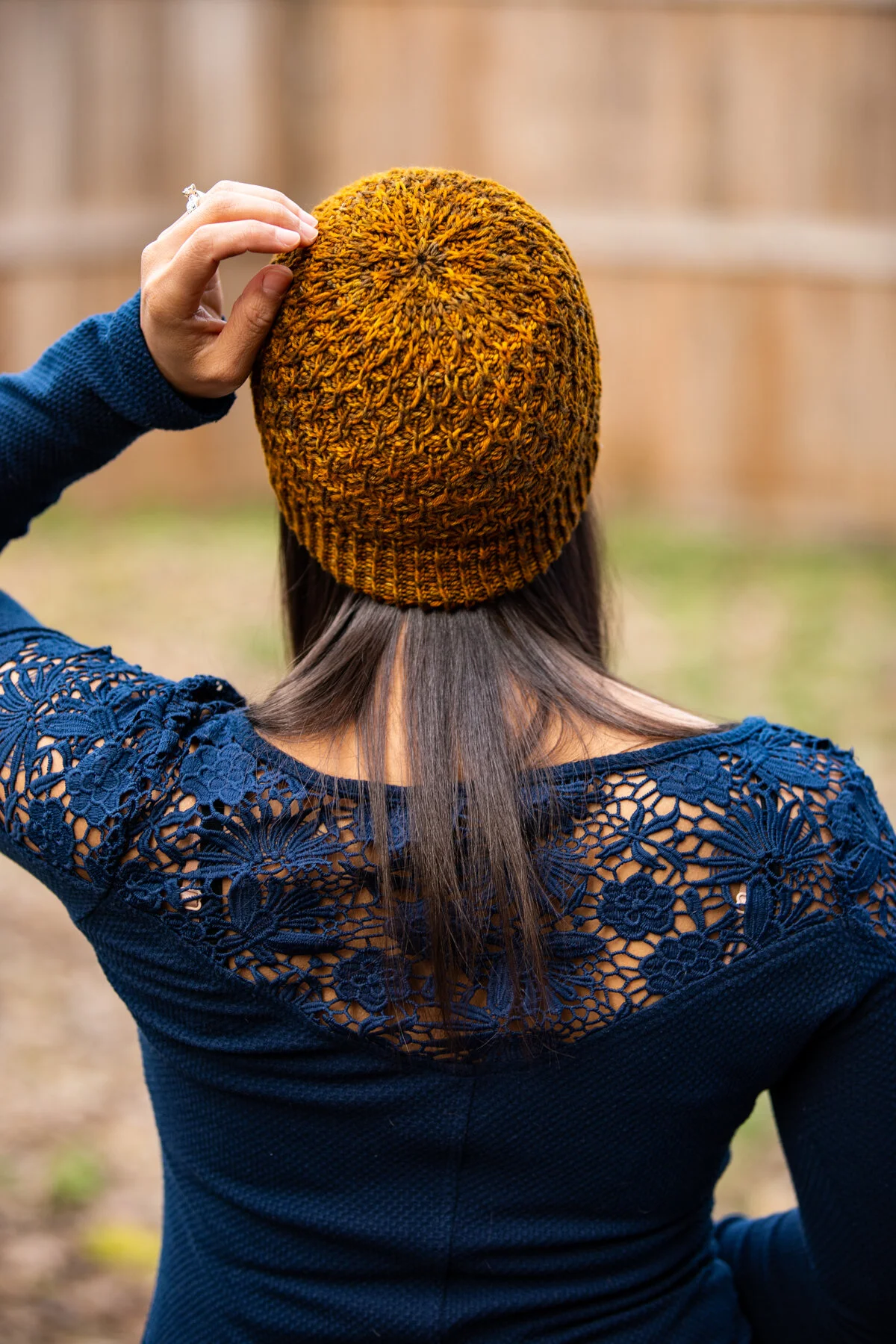 Back view of the Aslyn beanie in a lovely golden amber color, showing the detailed crown shaping and overall texture achieved with a sport weight yarn. PDF knitting pattern by Vanessa Smith Designs.