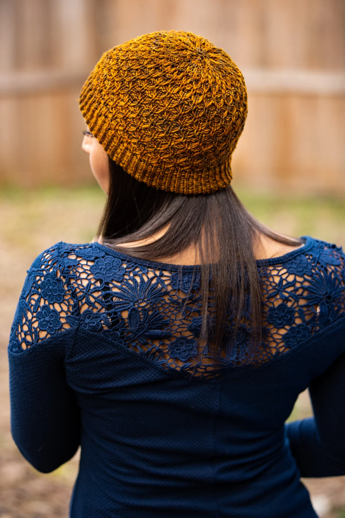 A worn side profile of the golden yellow Aslyn hat, showing its classic beanie shape and fit that makes for a cozy, comfortable knit you'll love to wear. PDF knitting pattern by Vanessa Smith Designs.