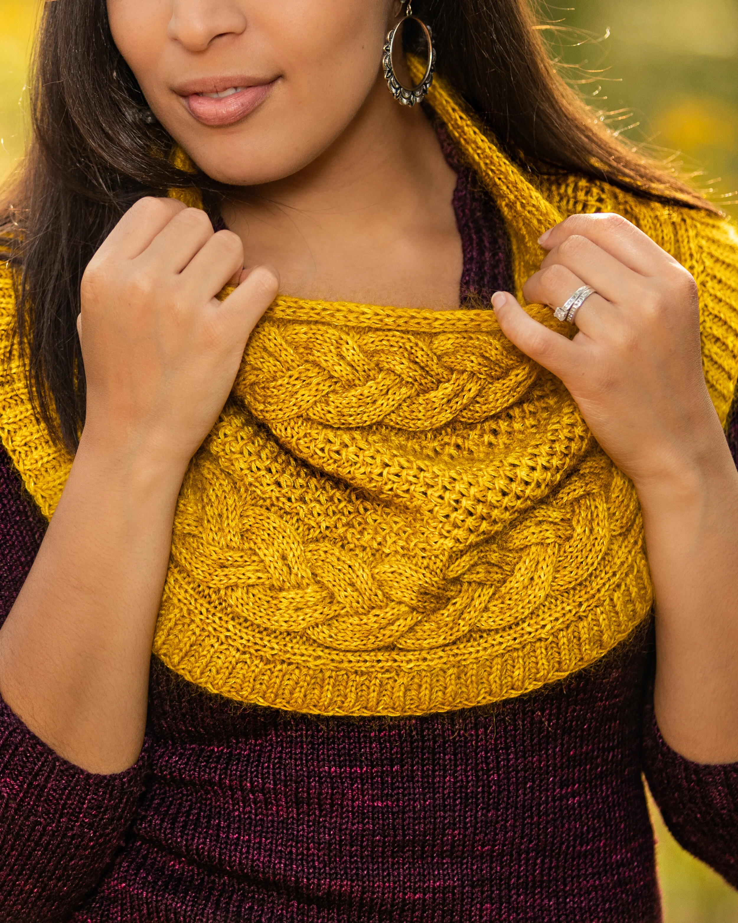 A closeup view of the i-cord edge; unique, double-braided cable; easy all-over lace stitch; and brioche-like, fisherman's ribbing in the Indira Cowl, a PDF knitting pattern by Vanessa Smith Designs.