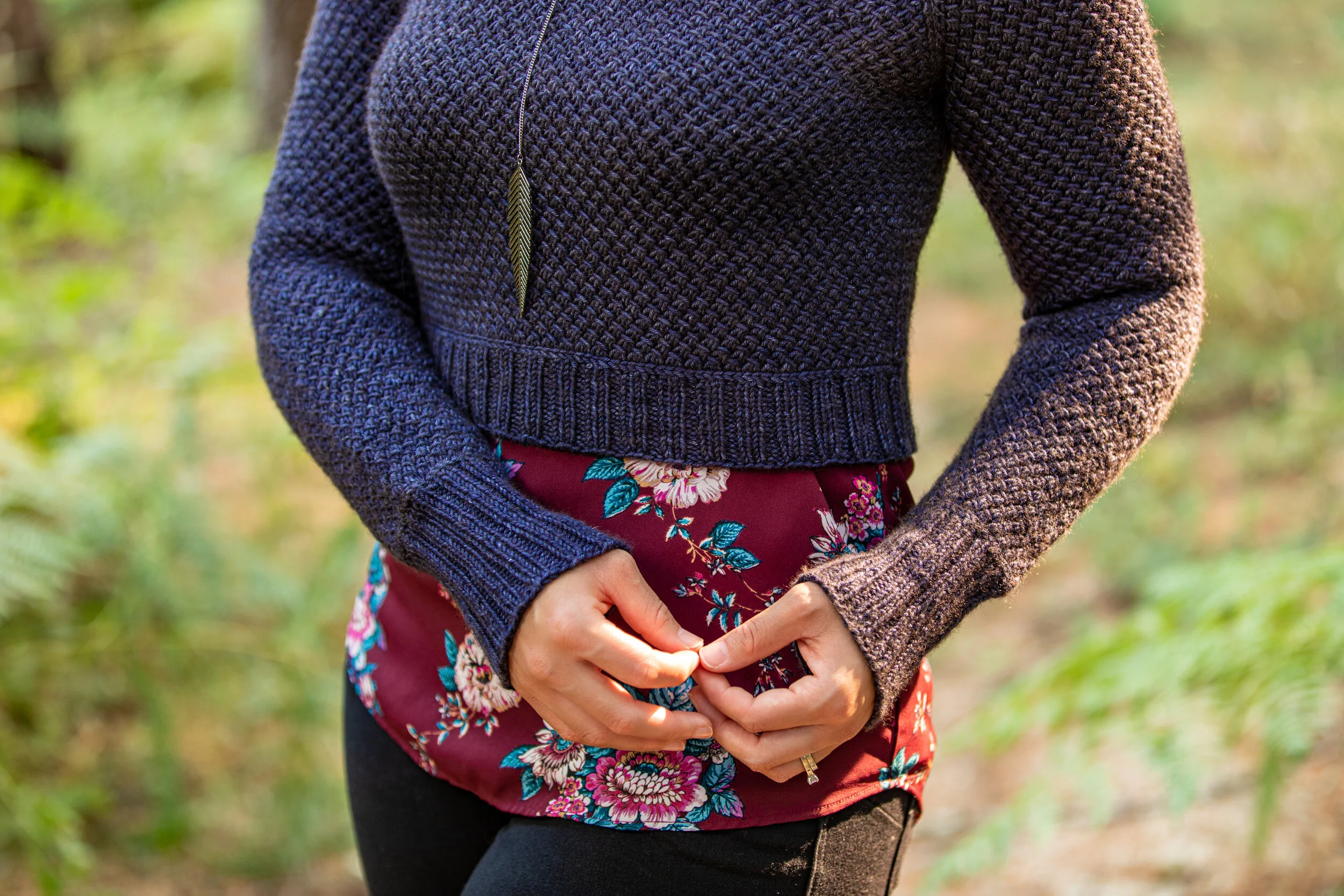 Close-up look at the intricate, well-thought details in Nydia, a seamless, top-down raglan sweater designed by BIPOC knit designer Vanessa Smith with lateral braids, allover texture & classic ribbing.