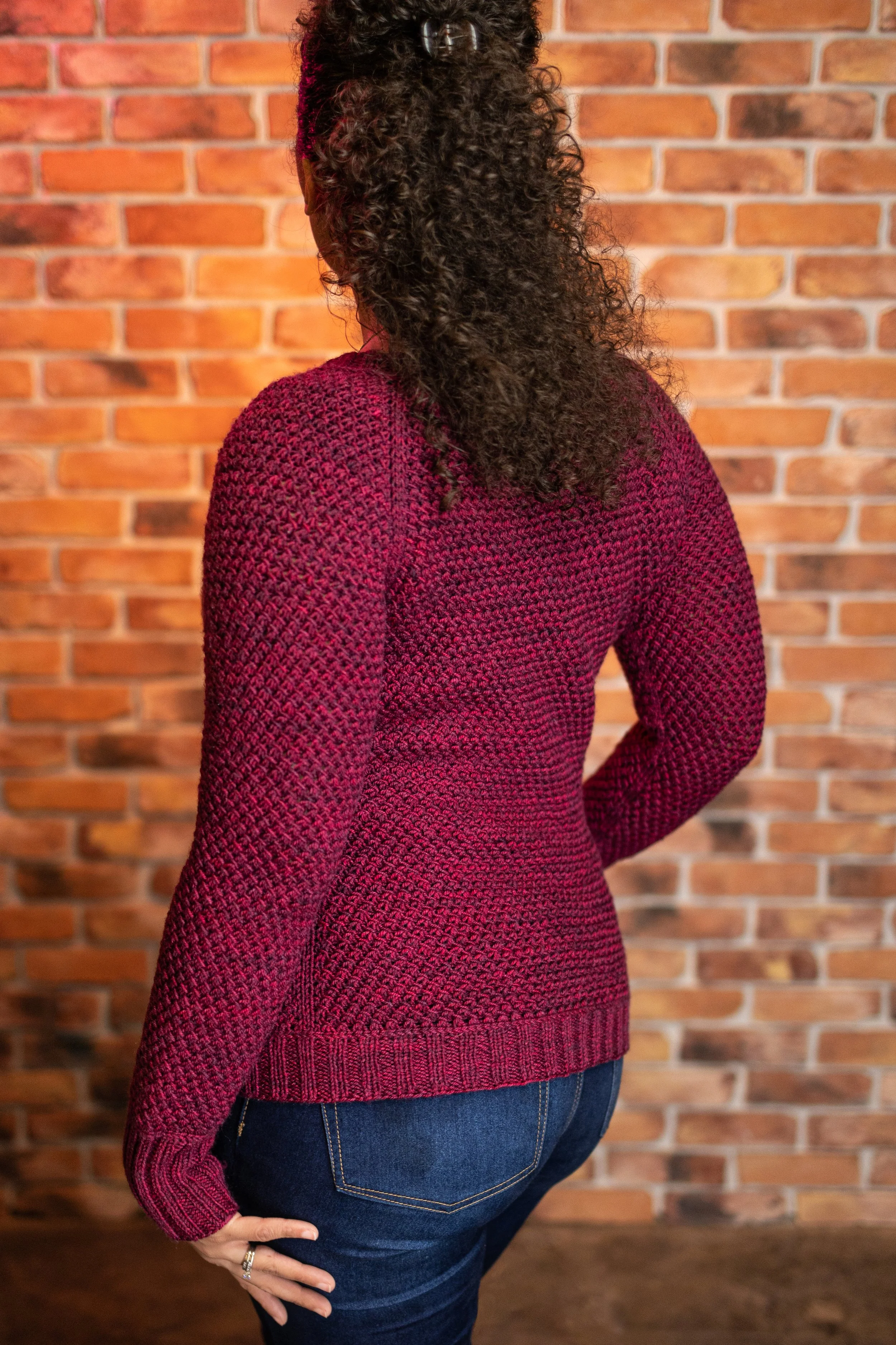 Back view of the red full-length Nydia Cardigan, highlighting its tailored fit and seamless construction. Size-inclusive knitting pattern designed for petite and plus-sized women by Vanessa Smith.