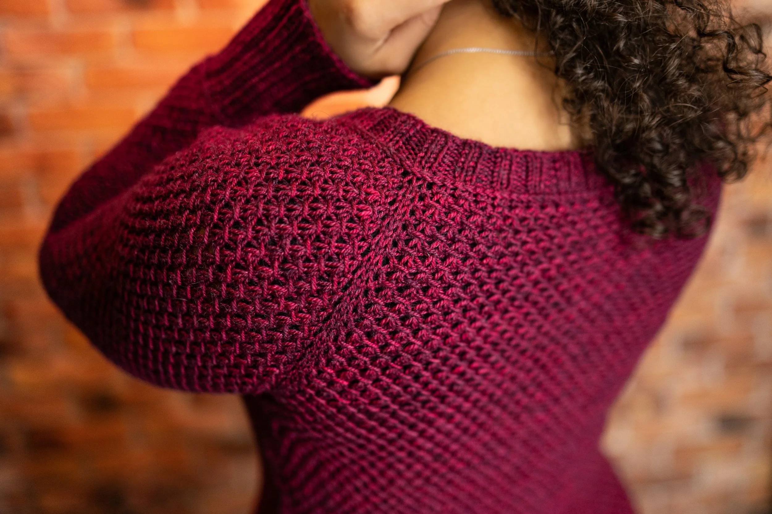 Detail shot showing the seamless raglan construction and tailored fit of the Nydia Cardigan, a modern knitting pattern designed for women in a beautiful, stretchy lace stitch pattern by Vanessa Smith.