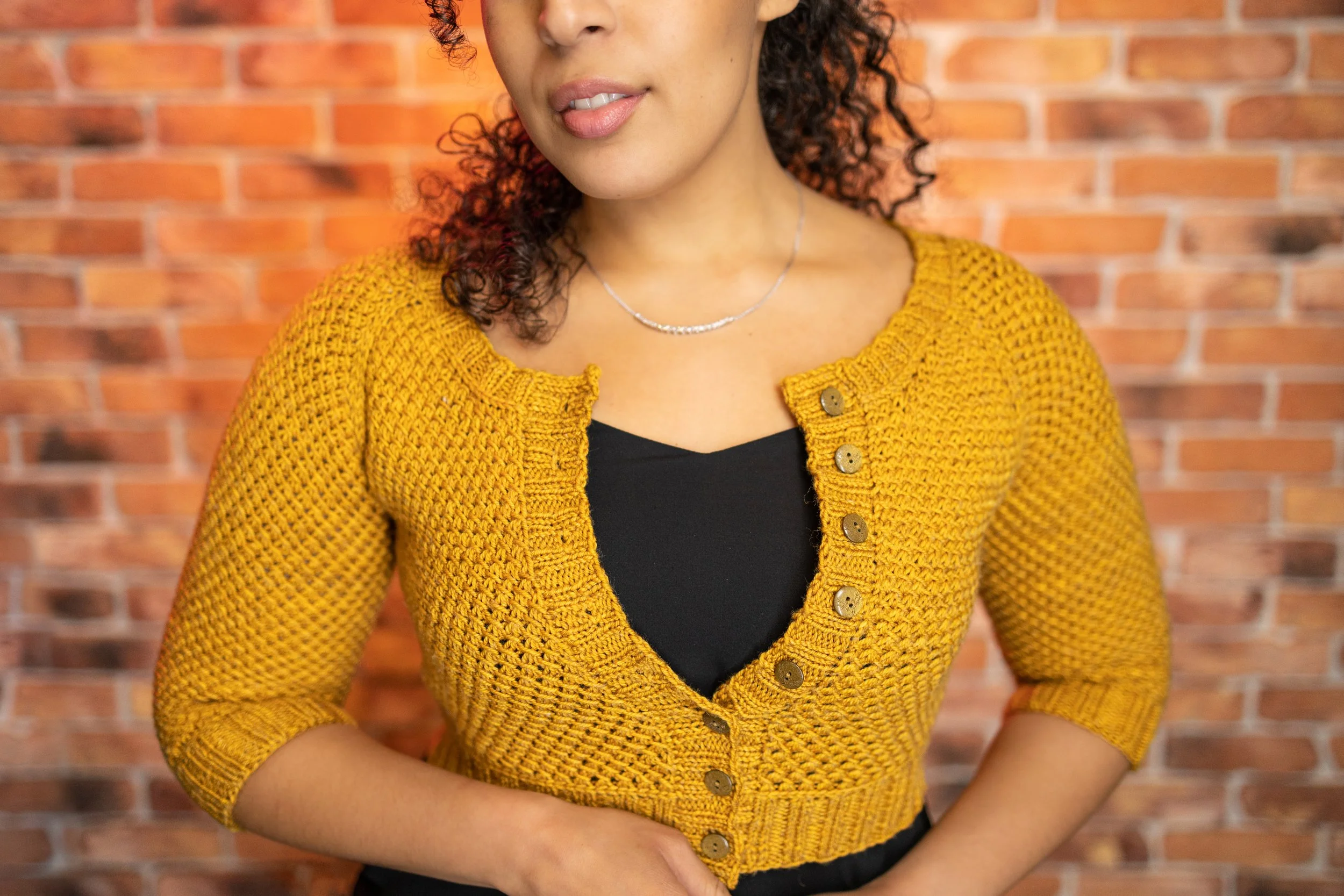 Front view of the versatile cropped Nydia Cardigan, a paid digital women's knitting pattern by Vanessa Smith Designs with inclusive sizing and lots of fit customization tips. Wear over tops or dresses