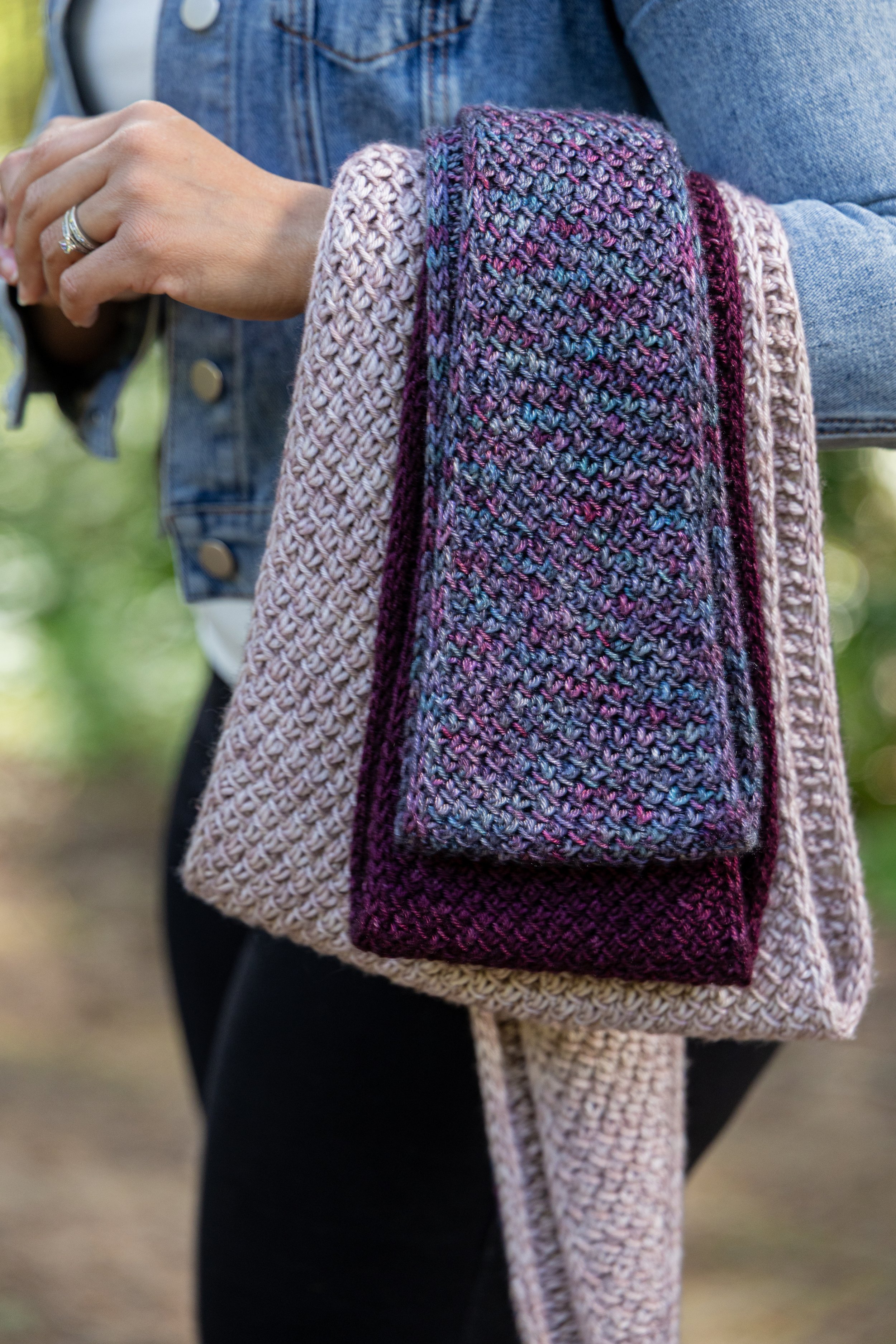 Detailed shot of all three sizes of the Tipping Point Scarf, a swatchless, beginner-friendly textured lace stitch scarf knit from side to side with increases and decreases and using any yarn weight.