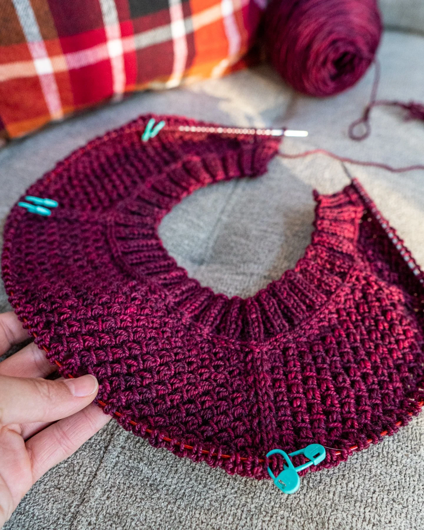 In-progress photo of the Nydia Cardigan—a size-inclusive, modular top-down raglan sweater knitting pattern designed for women—being made in a DK weight yarn and featuring a cozy, textured lace stitch.