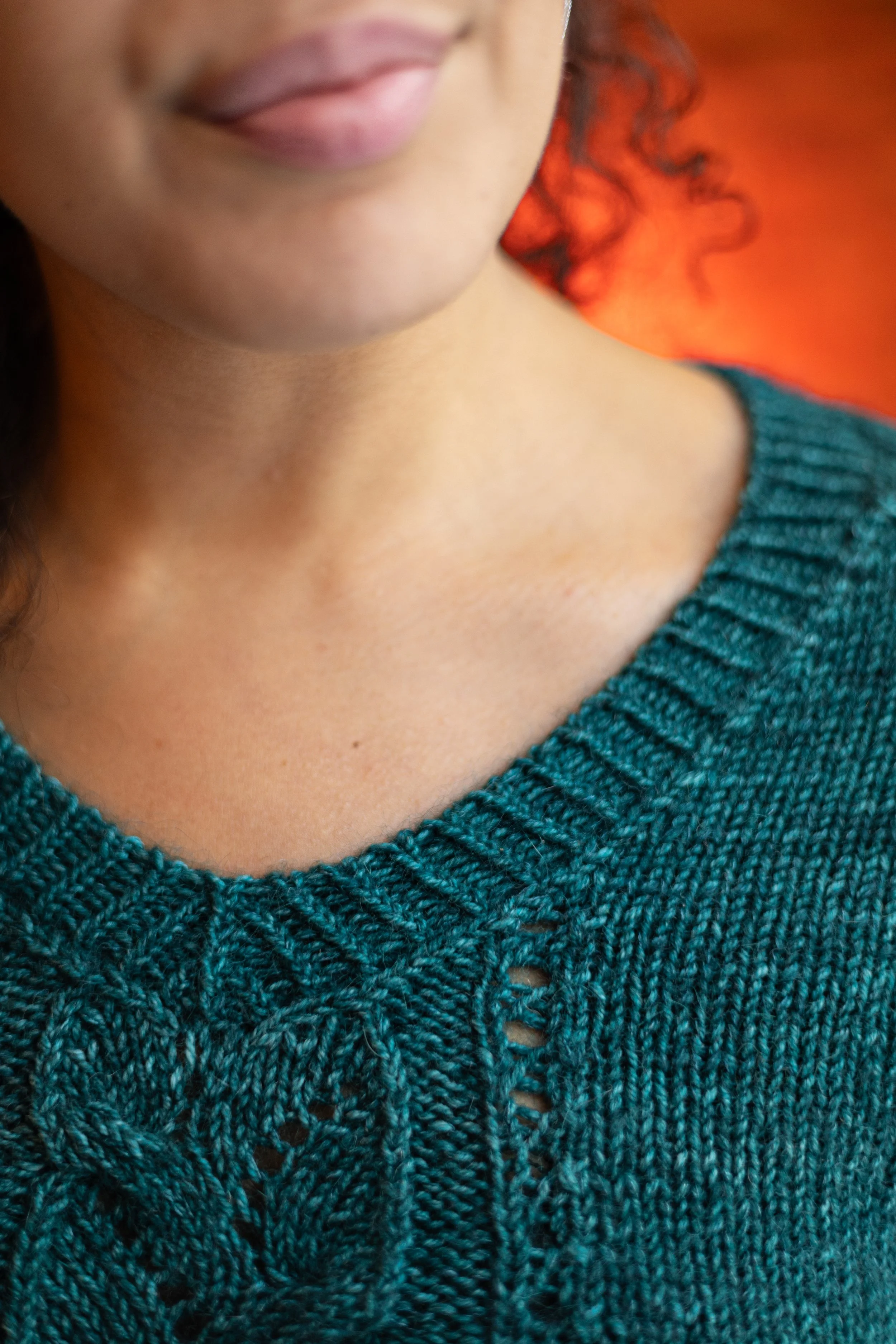 Close-up of the beautifully shaped V-neckline on the teal Meant to Vee sweater, showcasing neat finishing. PDF knitting pattern by Vanessa Smith Designs.