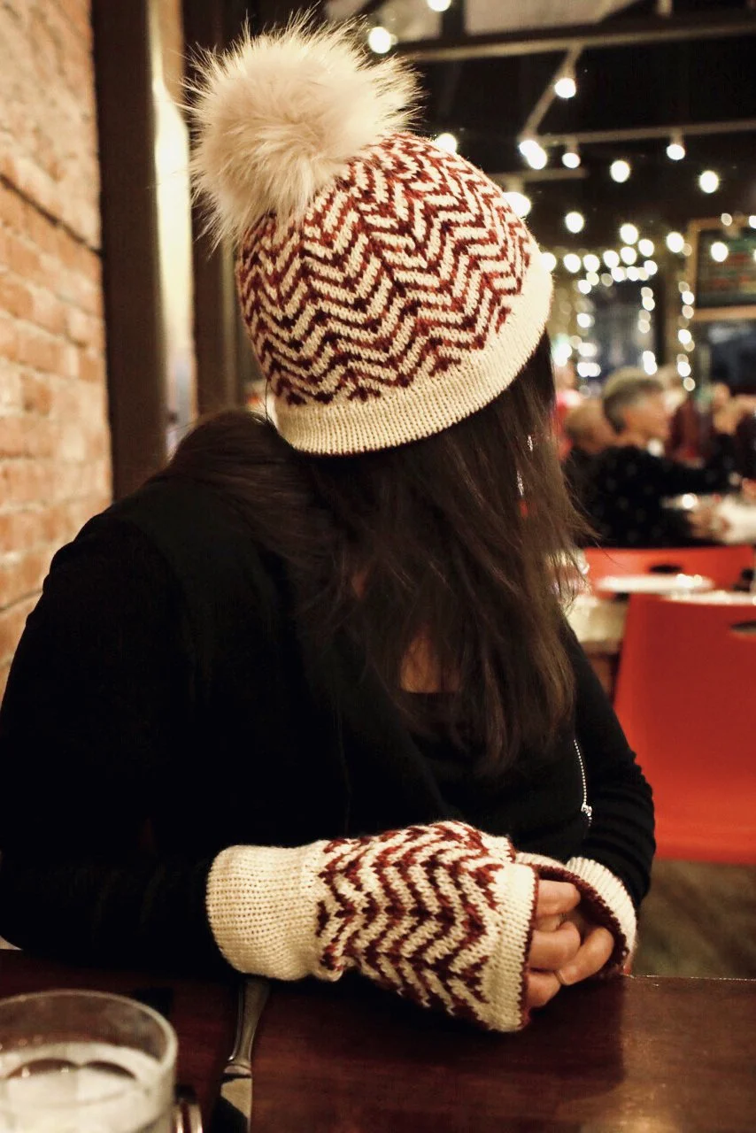 Side view of the Novemberist Hat, its fluffy topper, and the matching mitts using easy, beginner-friendly fair isle stranded colorwork for a striking effect. Fun & quick to knit in two DK weight yarns